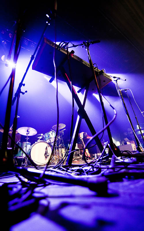 Dark and grainy image of a stage ready for a music band live performance