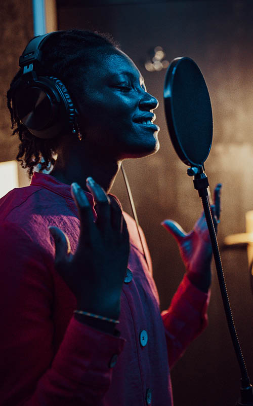 Black woman singing and recording in the music studio